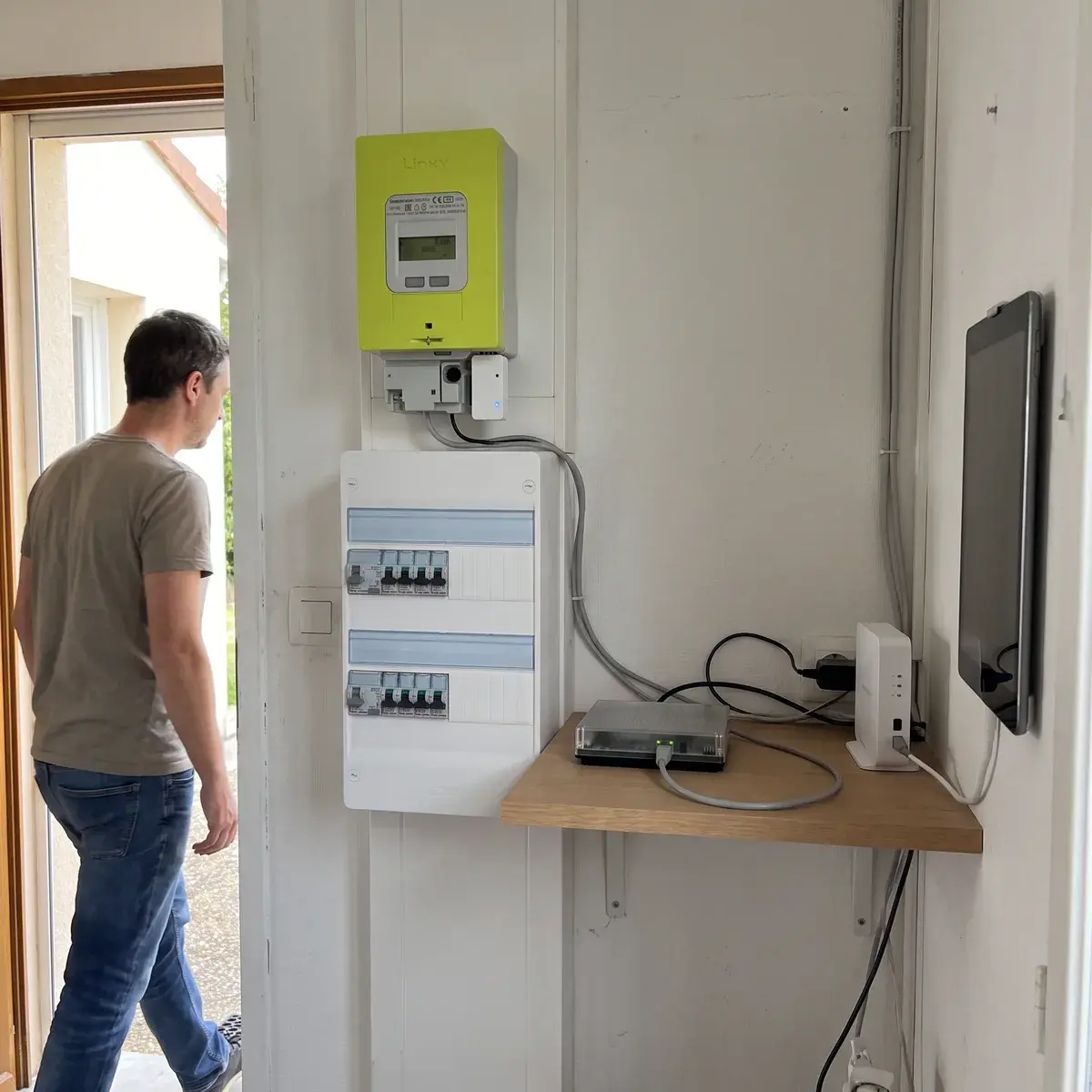 Box domotique Home Assistant Green posée sur une étagère à côté du compteur Linky équipé d’un module de téléinformation LiXee ZLinky, dans le cellier d’un pavillon.