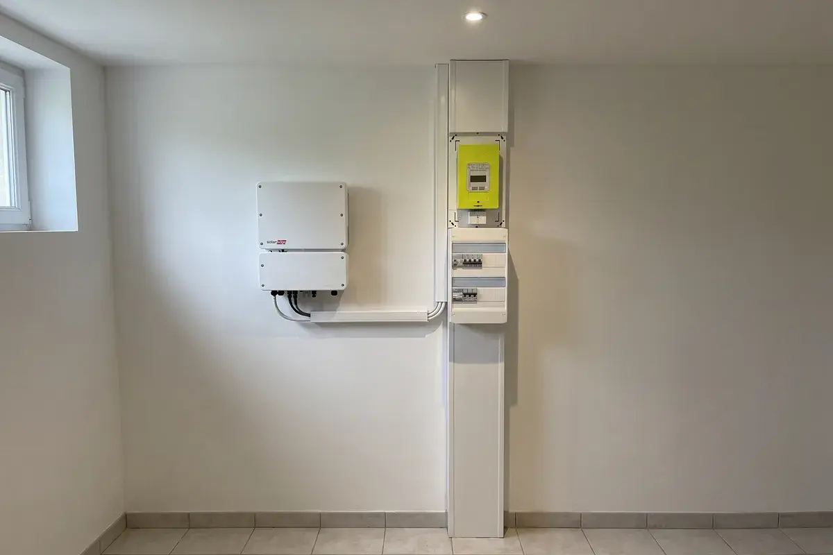 Onduleur SolarEdge Home Hub fixé à côté d’une gaine technique logement avec compteur Linky et tableau électrique.