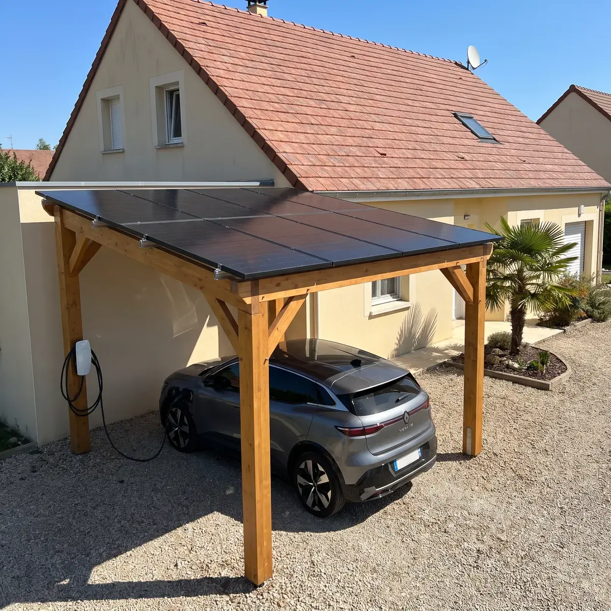 Ombrière en bois couverte de modules DualSun FLASH, avec une borne Tesla Wall Connector qui recharge une Renault Mégane E-Tech.