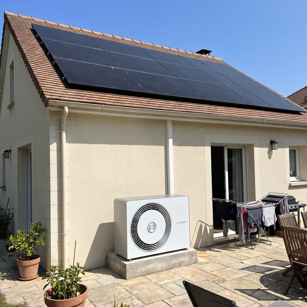 Arrière d'un pavillon avec des panneaux solaires sur le toit et une pompe à chaleur Bosch Compress 5800i AW.