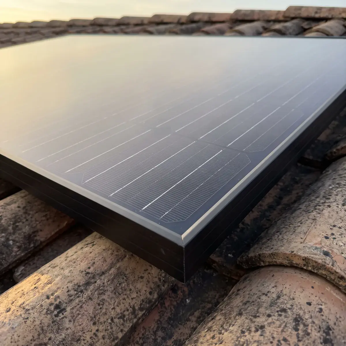 Gros plan sur les cellules d'un module Voltec Solar TARKA posé sur une toiture en tuiles.